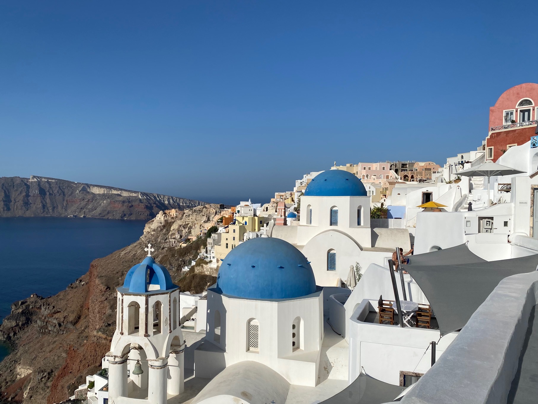 View of the Santorini caldera with the three blue domes of the churches | Best Things to Do in Santorini 2022 | greekislandbucketlist.com